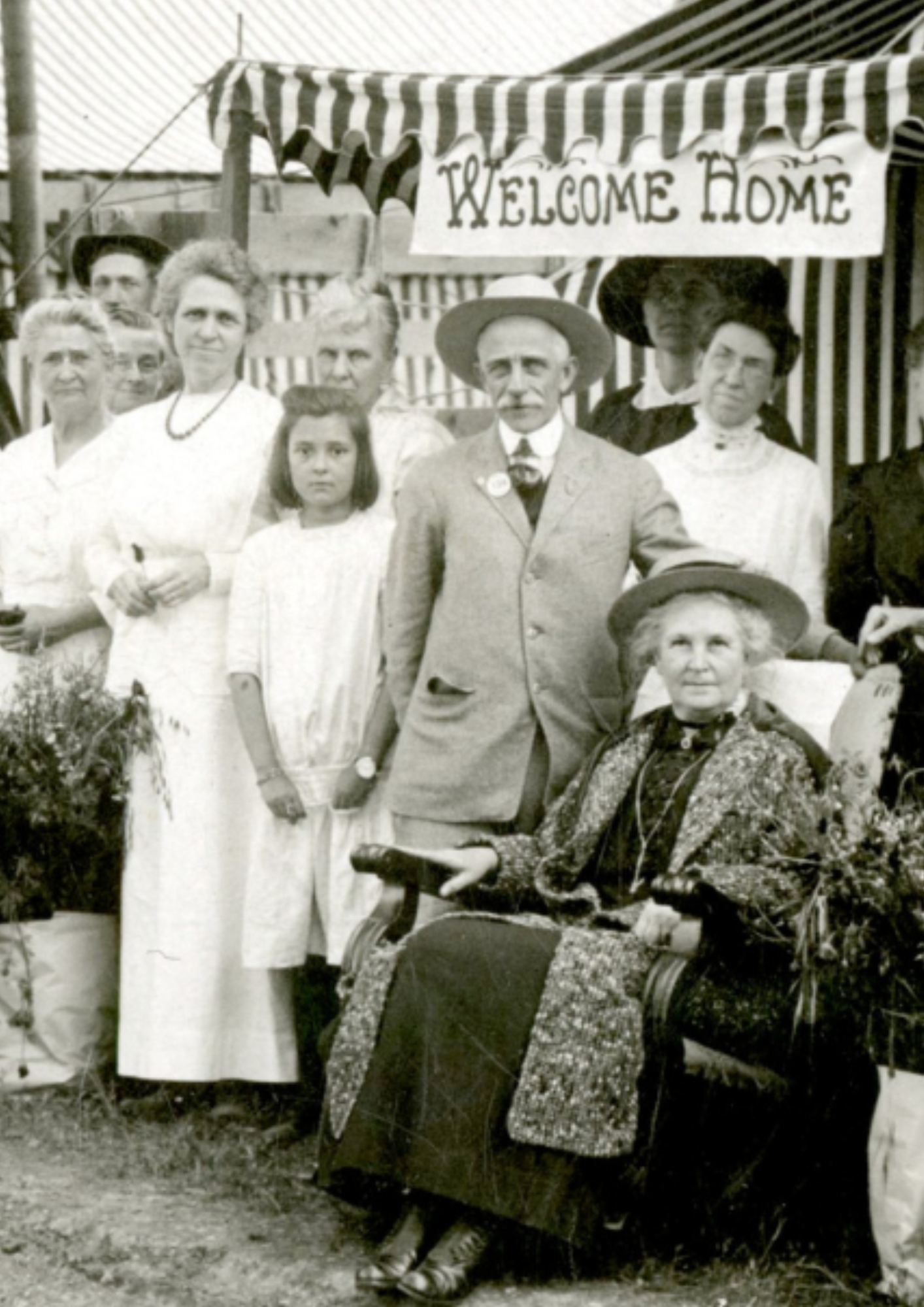 Historic photo of people at Tent City with a "Welcome Home" sign.