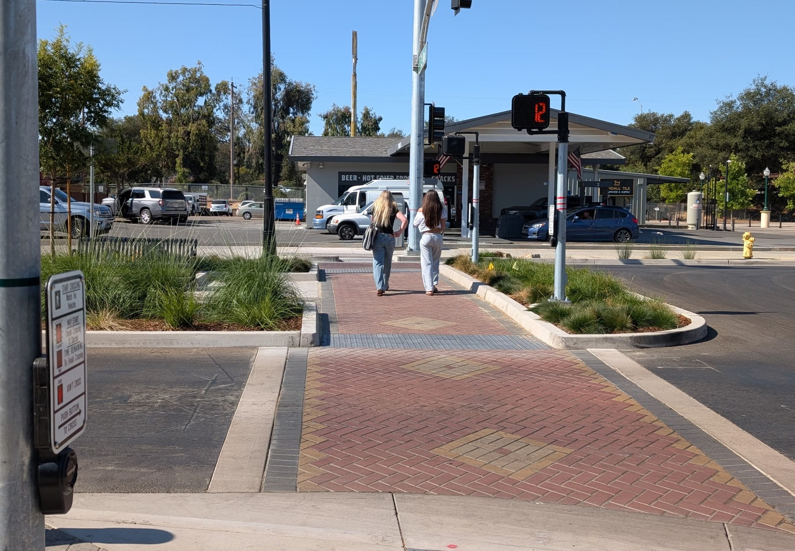 Crosswalk at El Camino Real and East Mall with two pedestrians using it to cross the road.
