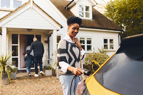 A woman plugging in an ev at home