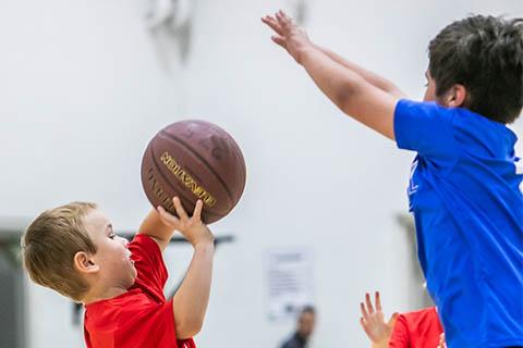 Kindergarten age kids playing basketball.