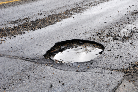 Pothole in the road full of water.