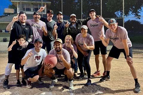 Group photo of the 2025 Kickball Champs smiling and holding up an index finger to indicate they are number 1.