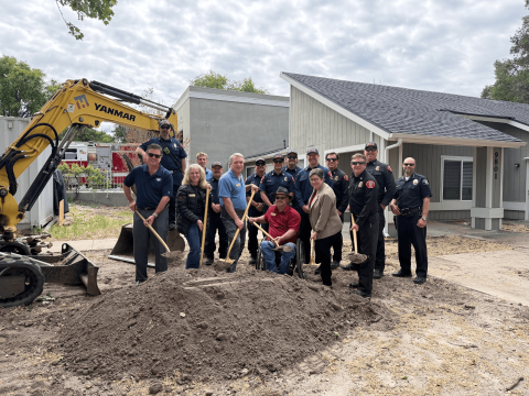 Atascadero Fire & Emergency Services staff standing with the Fire and Police Chiefs, City Manager, and City Council Members beside an excavator and large dirt pile at the Fire Station 2 groundbreaking ceremony, while Council Members, the Fire Chief, and the City Manager hold ceremonial shovels filled with dirt.