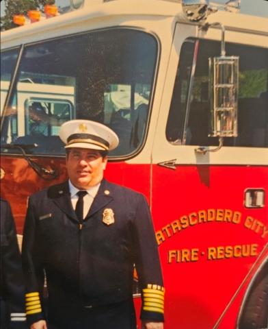 Former City of Atascadero Fire Chief Michael Paul McCain standing in full uniform in front of a fire engine with “Atascadero City Fire & Rescue” visible on the vehicle.