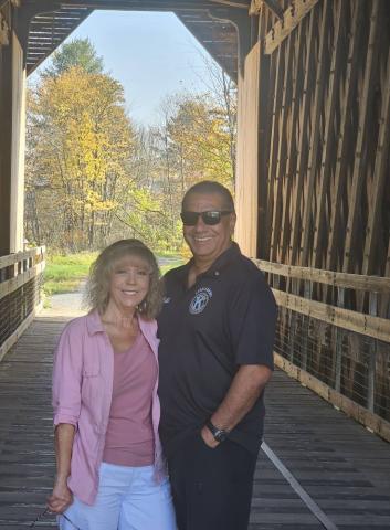 2025 Champion of the Community, Albert Almodova, standing inside a covered bridge while promoting Kiwanis event in Vermont.