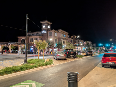 Nighttime view of El Camino Real between East Mall and West Mall after the ECR Project improvements, highlighting center median parking, landscaping, and additional lighting.